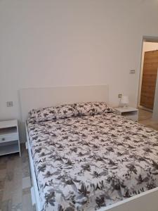 1 Schlafzimmer mit einem Bett mit Blumenbettdecke in der Unterkunft Casa Gelsomino in Rimini