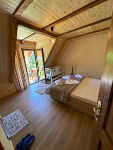 1 dormitorio con 1 cama y suelo de madera en Royal Land en Theth
