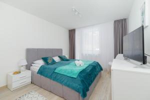 a white bedroom with a bed and a television at Family Apartment Droga na Bystre by Renters in Zakopane