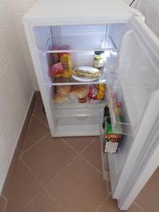 um frigorífico com a porta aberta com comida dentro em Prenoćište Dubravka em Livno
