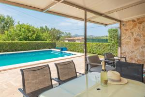 a table and chairs with a bottle of wine on a patio at Vacaciones ideales en Villa Fernando con piscina! in Manacor