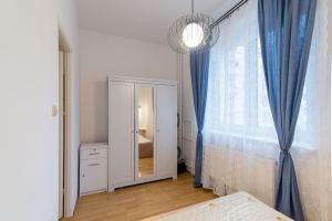 グディニャにあるMieszkanie Gdyniaのベッドルーム(大きな窓、青いカーテン付)
