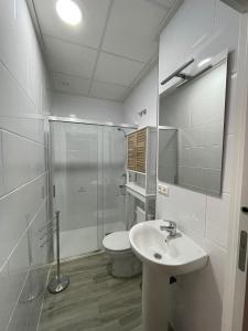a bathroom with a toilet and a sink and a shower at Apartamento Gabarron in Mula +8 photos