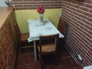 un tavolino con un vaso di fiori sopra di Quarto Privado Grande Completo a Agualva