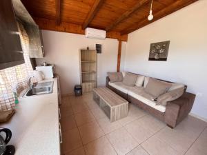 sala de estar con sofá y lavamanos en Luxury house 15 minutes from ATH en Spáta