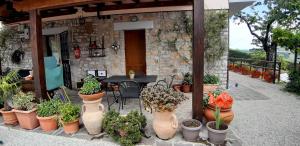 een patio met een tafel en een bos potplanten bij B&B Le Terrazze in Perugia