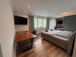 Schlafzimmer mit einem Bett und einem Holztisch in der Unterkunft Bergpanorama - Suite Willingen in Willingen