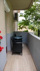un patio con 2 sillas y una mesa en el balcón en Apartments Biser, en Vrnjačka Banja