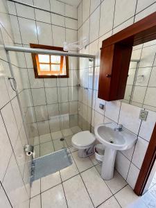 łazienka z toaletą i umywalką w obiekcie Pousada Recanto da Traineira w mieście Ubatuba