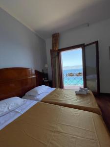 a bedroom with a bed with a view of the ocean at Hotel La Lampara in Reggio Calabria