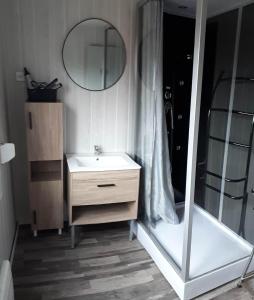 La salle de bains est pourvue d'un lavabo et d'un miroir. dans l'établissement le familial avec spa, sauna salle de jeux, à Xonrupt-Longemer