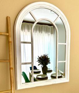 a mirror with a table with plates and a vase at Apartamento La Rosa - RECIÉN REFORMADO in Córdoba