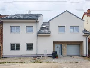 a white house with a black roof at Apartmán U sklepů in Šardice