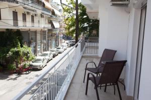 a balcony with chairs and a view of a street at Downtown supreme apartment kavala in Kavála