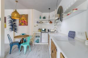 cocina con mesa y sillas azules en Petite Maison Victoria by Caleta Homes en Málaga