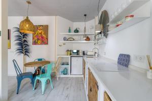 cocina con mesa y sillas azules en Petite Maison Lili by Caleta Homes, en Málaga