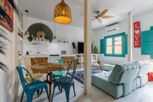 Una cocina y una sala de estar con mesa y sillas. en Petite Maison Lili by Caleta Homes, en Málaga