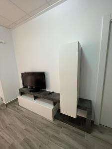 uma sala de estar com televisão numa parede branca em Apartamento Gabarron em Mula