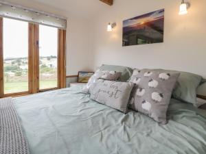 a bedroom with a bed with pillows on it at Tan Y Castell Shepherds Hut in Llangollen