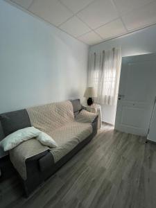uma sala de estar com um sofá e uma mesa com um candeeiro em Apartamento Gabarron em Mula