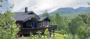 a house on a hill with mountains in the background at Large and cosy mountain cabin in Sykkylven