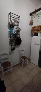 eine Küche mit 2 Stühlen und einem weißen Kühlschrank in der Unterkunft Corazón de Mágina in Bedmar