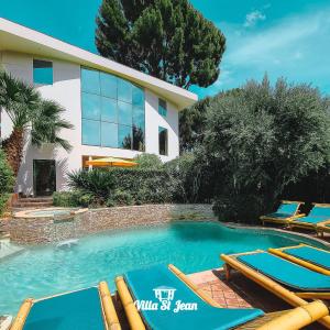 une villa avec une piscine en face d'une maison dans l'établissement Villa St Jean SUITE Romantique, à La Ciotat