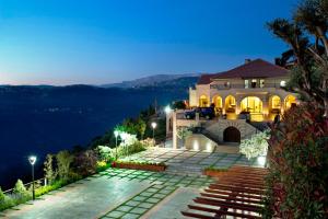 a house on top of a mountain at night at Cherry Blossom Boutique Hotel in Bḩamdūn