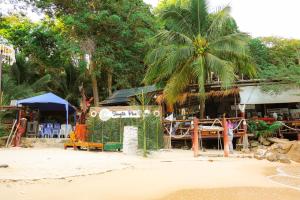 a beach with a resort with palm trees and a building at Tongta Phaview Resort in Ko Samed