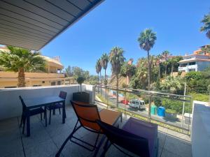 een balkon met een tafel en stoelen en palmbomen bij ArtPlatinum SUITES&APARTMENTS in Benalmádena