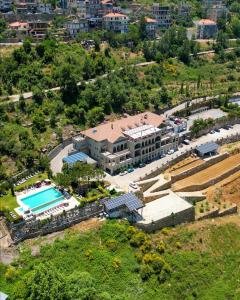 an aerial view of a house with a swimming pool at Cherry Blossom Boutique Hotel in Bḩamdūn