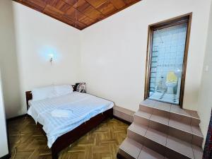 1 dormitorio con 1 cama y ventana con aseo en Mahali Muzuri, Arusha en Arusha