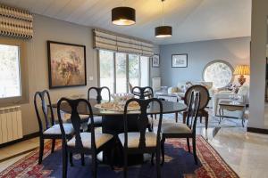 a dining room and living room with a table and chairs at Cherry Blossom Boutique Hotel in Bḩamdūn