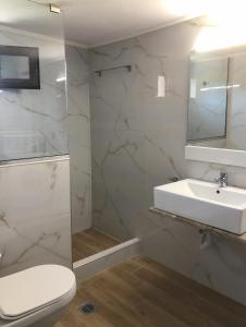 a bathroom with a sink and a toilet and a mirror at Palio beach house in Paleo Tsifliki +59 photos