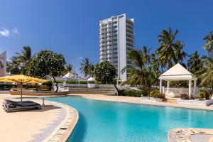 a swimming pool with a building in the background at Sun N Sand Beach Resort in Mombasa