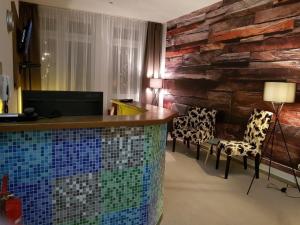 una habitación de hotel con un mostrador de mosaico y sillas en Arthotel, en Bad Pyrmont
