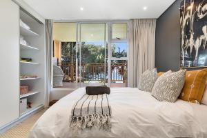 a bedroom with a large white bed with a window at Stylish Beachscape in Umdloti in Umdloti
