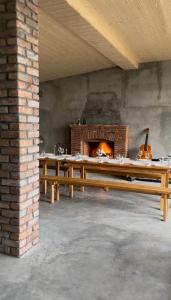 einen Holztisch in einem Zimmer mit Kamin in der Unterkunft ,,Anna's" Guesthouse in Nizhniy Alvani