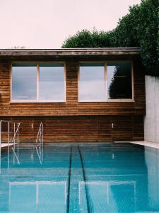 une maison avec une piscine à côté d'un bâtiment dans l'établissement Genusshotel Riegersburg, à Riegersburg