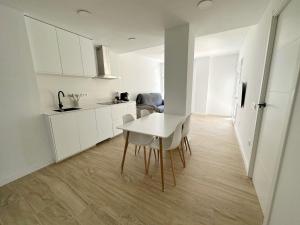 a white kitchen with a white table and chairs at Apartamento Galiria, Pals in Pals
