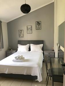 a bedroom with a white bed with two towels on it at Palio beach house in Paleo Tsifliki