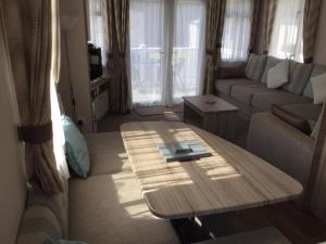 a living room with a couch and a coffee table at Poppy 57, Oakdene Forest Park in Bournemouth