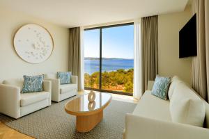 a living room with white furniture and a large window at TRS Ibiza Hotel - Adults Only in San Antonio
