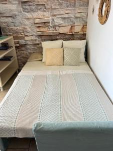 a bed in a room with a brick wall at Eco Sunshine Apartments Lumbarda in Lumbarda