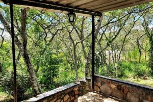 een raam in een huis met uitzicht op een bos bij 10 guest stay in the mountains of Nyanga! in Juliasdale