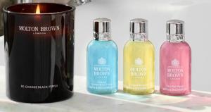 three bottles of different colored liquids next to a candle at Sivota Deamaris Luxury Boutique Hotel in Syvota