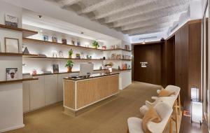 a office with a reception desk and chairs in a room at The Moods Catedral Hostal Boutique in Barcelona