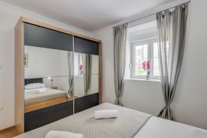 a bedroom with a bed and a large mirror at Da Da in Kaštela