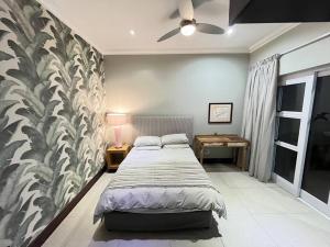 1 dormitorio con 1 cama grande y 1 mesa en Marina House, en Port Alfred