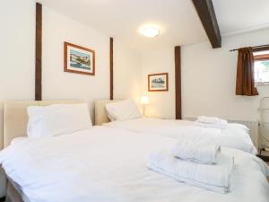 dwa łóżka w pokoju z białą pościelą w obiekcie Cranesbill Barn w mieście Kirkby Stephen